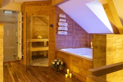 Salle de bain en bois avec spa et sauna vitré.